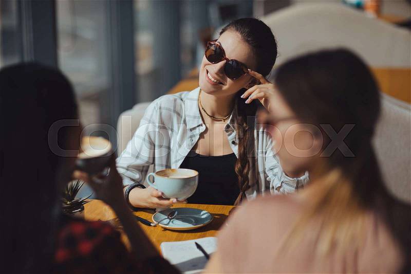 Young attractive multicultural women on coffee break in cafe , stock photo