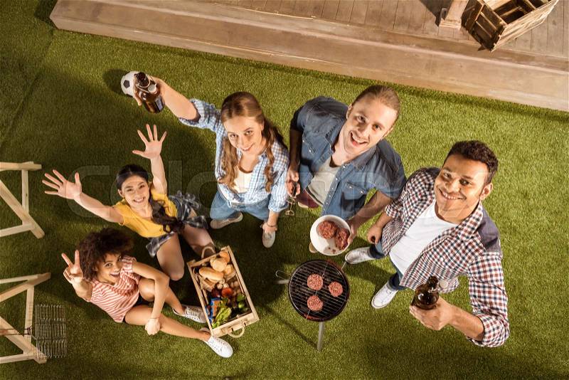 High angle view of happy young friends grilling burgers and drinking beer , stock photo
