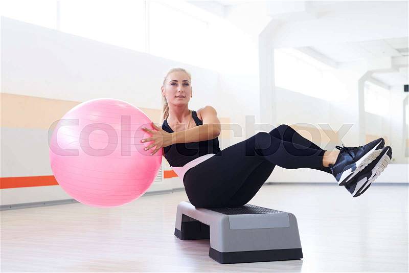 Close-up shot of slim fitness instructor exercises with fitball. Abdominal, sports equipment, stock photo