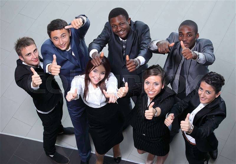 Elevated view of large group of multiethnic business people cheering and showing thumbs up, stock photo