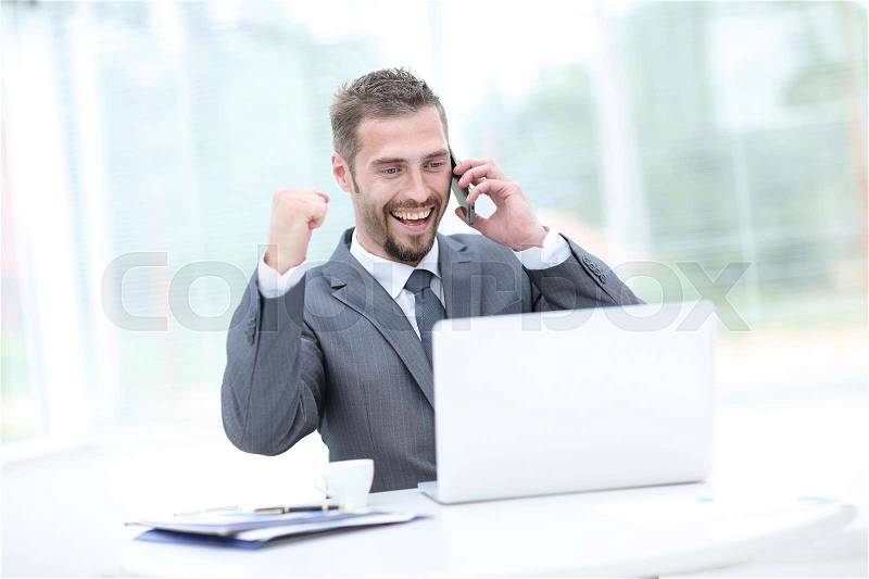 Happy smiling businessman working with laptop and calling, stock photo