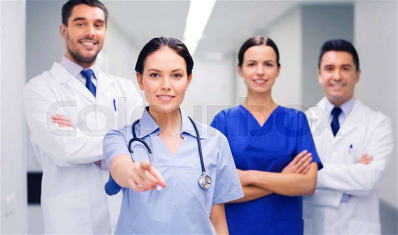 Clinic, profession, people, health care and medicine concept - group of happy medics or doctors pointing finger on you at hospital corridor, stock photo