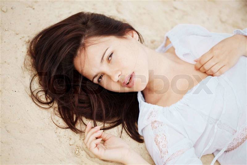 Young woman resting at beach near the sea, stock photo