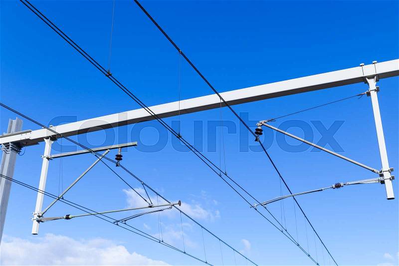 Overhead lines on Dutch railway under blue sky, stock photo