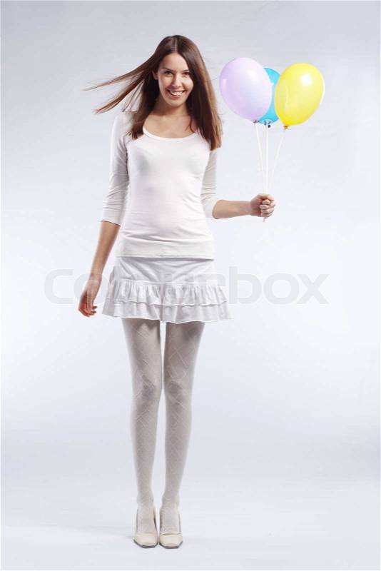 Fashion shot of young beautiful woman holding holiday balloons in her birthday, stock photo