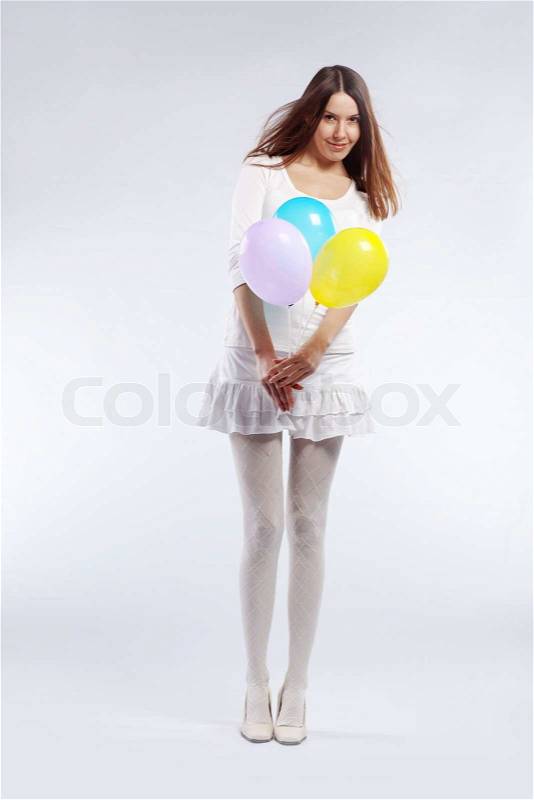 Fashion shot of young beautiful woman holding holiday balloons in her birthday, stock photo