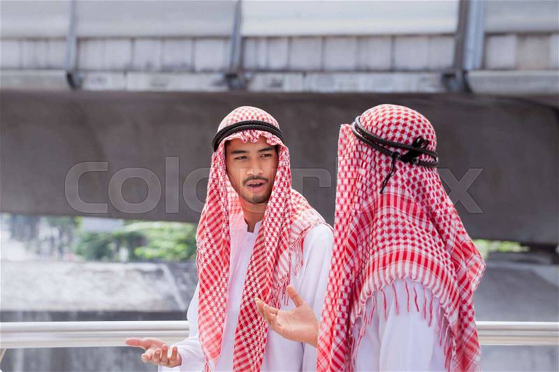 Two arabian businessman discuss, advise and walk together around modern city, stock photo