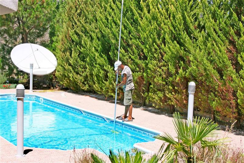 Swimming pool cleaner during his work, stock photo