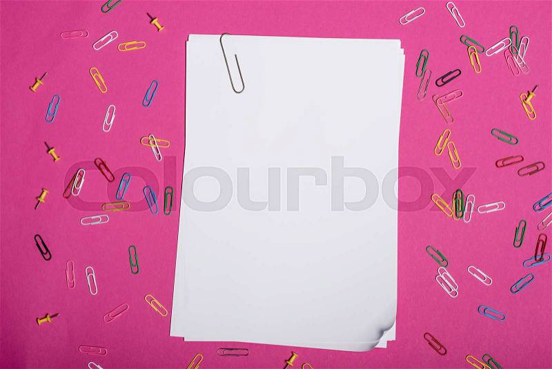 Top view of blank white papers and colorful paper clips isolated on pink, stock photo