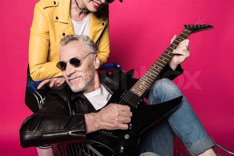 Cropped shot of stylish senior couple having fun together with electric guitar , stock photo