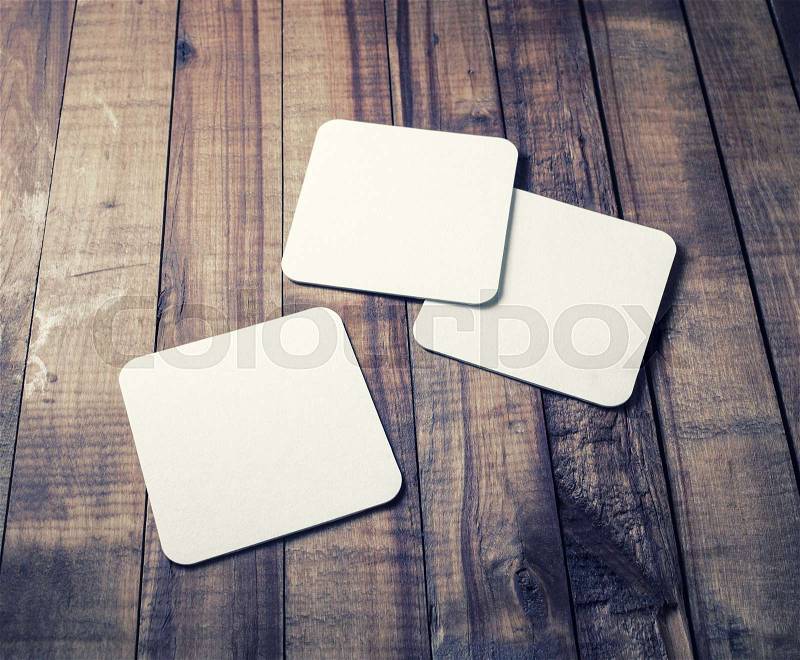 Photo of three blank beer coasters on vintage wood table background. Blank template for your design, stock photo
