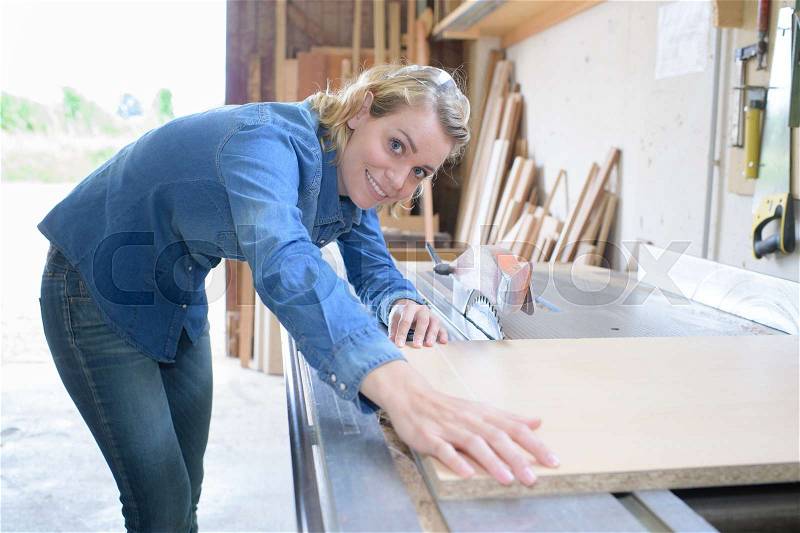 Woman builds model house from wooden blocks, stock photo