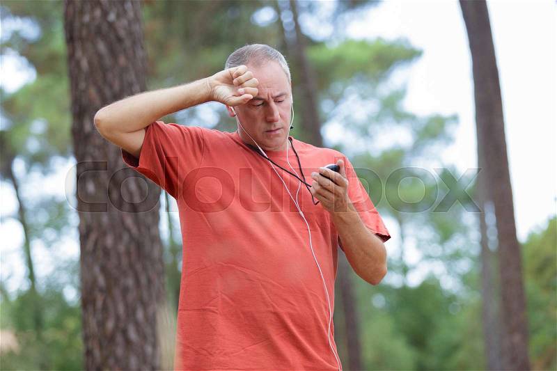 Male using sport watch for timing running workout, stock photo