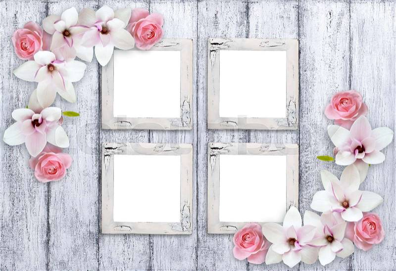 Four retro empty photo frames with magnolia flowers and roses on background of shabby wooden planks in rustic style, stock photo