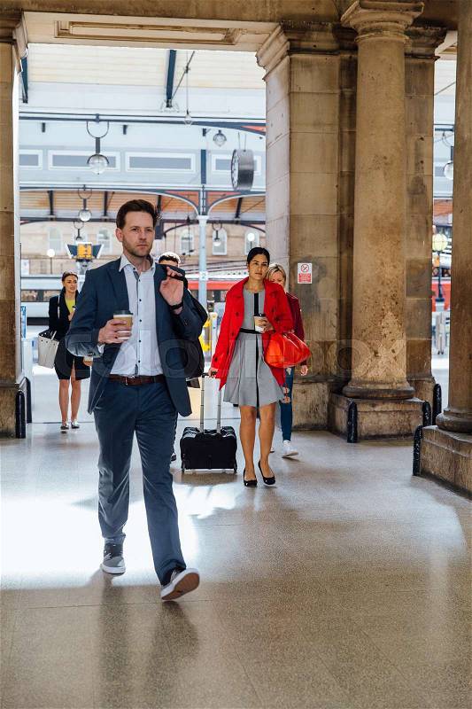 Businesspeople are leaving the train station to commute to work, stock photo