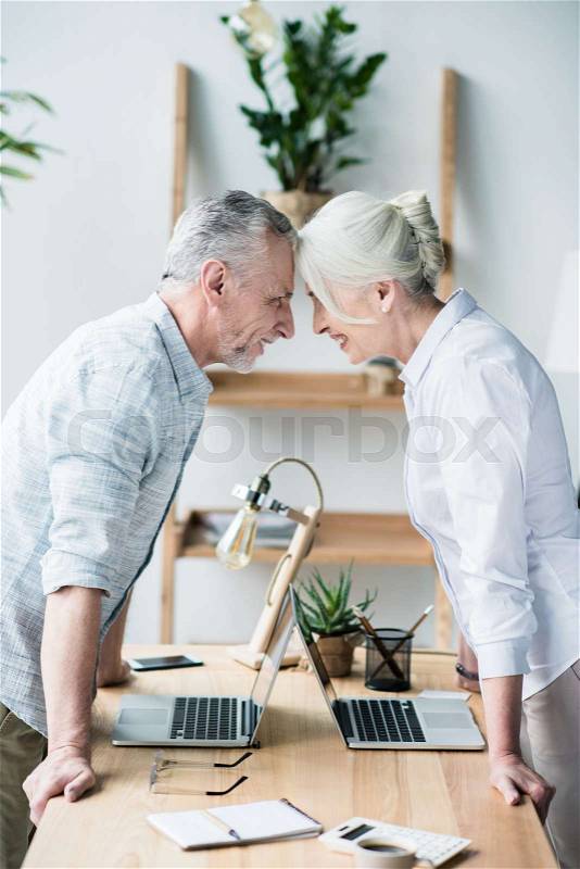 Senior business people standing head to head, stock photo