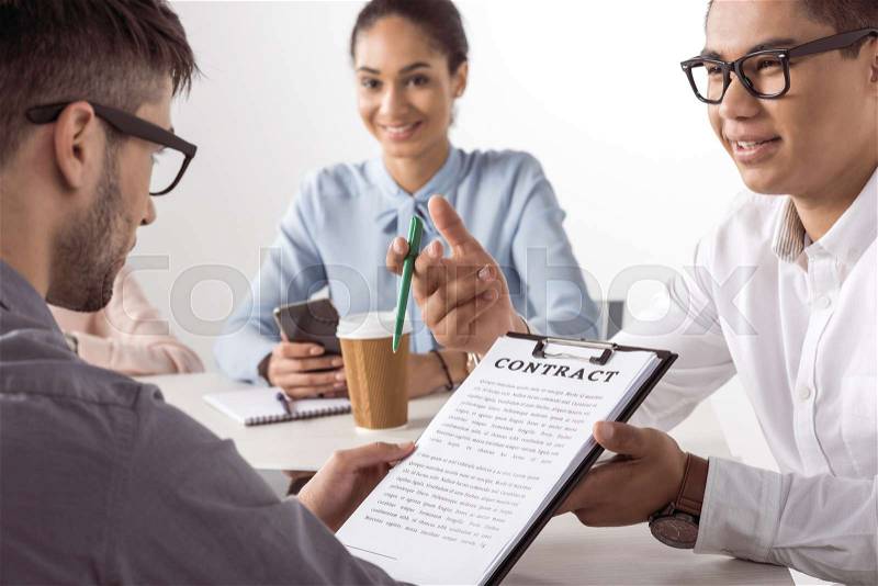 Young executive offering contract to businessman at placement interview, stock photo