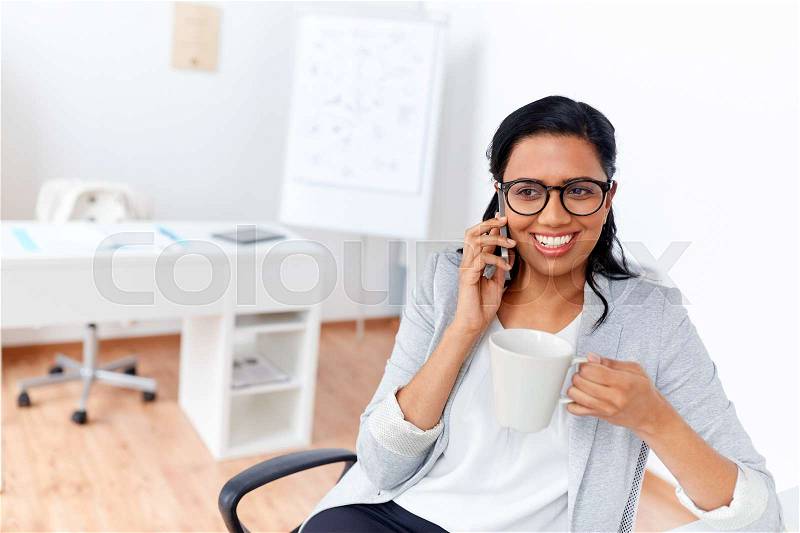 Business, communication and people concept - happy businesswoman or secretary calling on smartphone and drinking coffee at office, stock photo