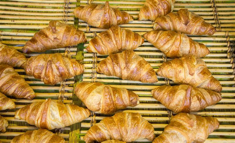 Freshly baked French croissants in street bakery store , stock photo