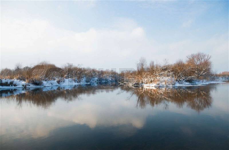 Winter river. Winter landscape with a quiet river and falling snow, stock photo
