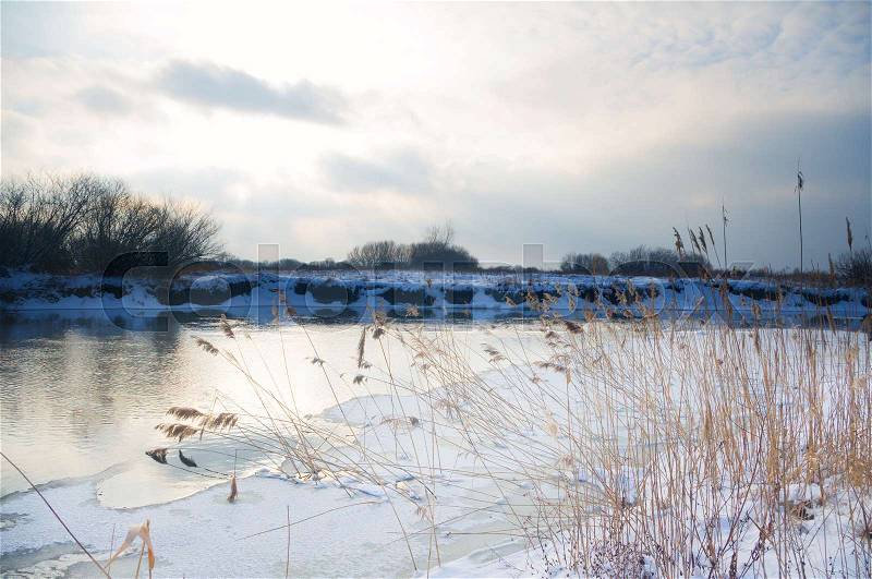 Winter river. Winter landscape with a quiet river and falling snow, stock photo