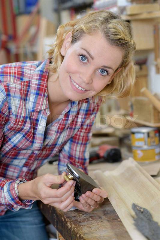 Young woman carpenter smiling at the camera, stock photo