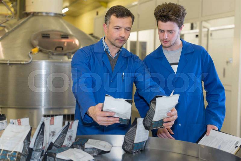 Two men in workwear at the factory, stock photo