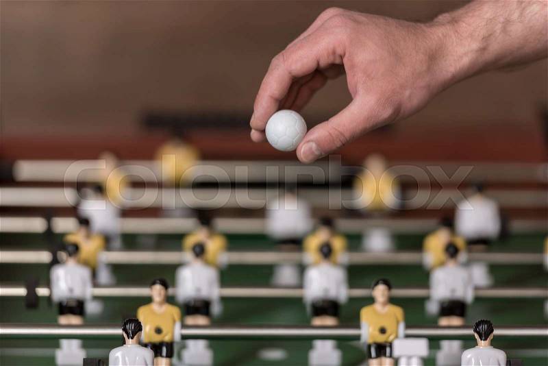 Close-up view of foosball and hand with ball, selective focus , stock photo