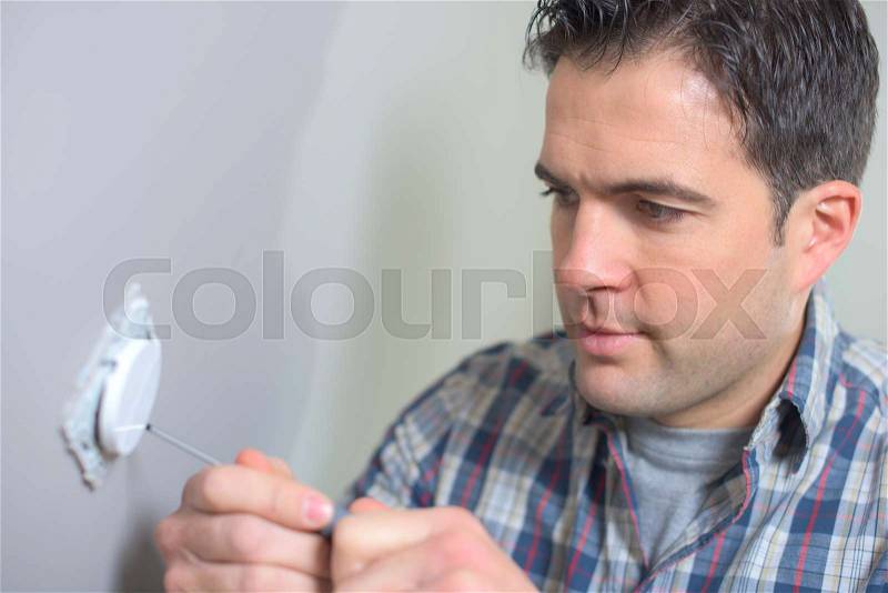 Electrician installing a wall power socket close up photo, stock photo