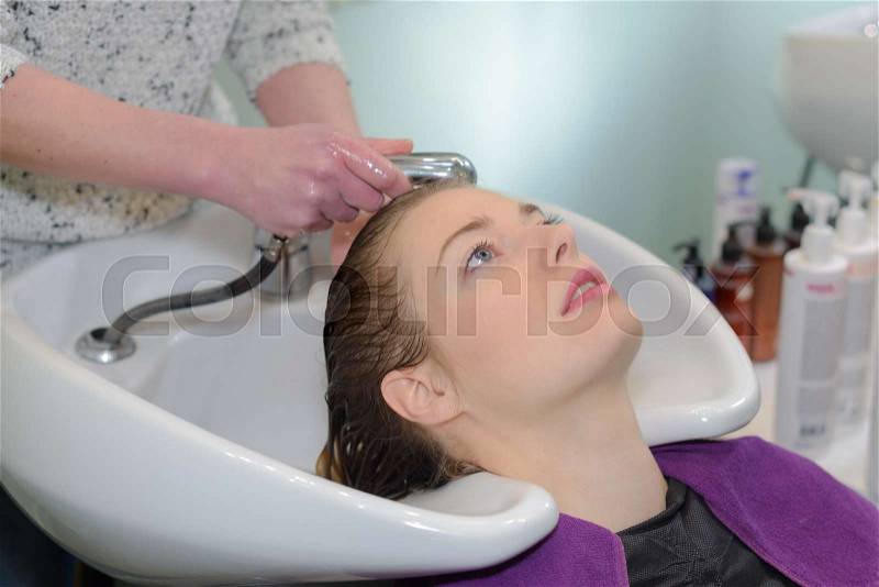 Hairdresser salon woman during hair wash, stock photo