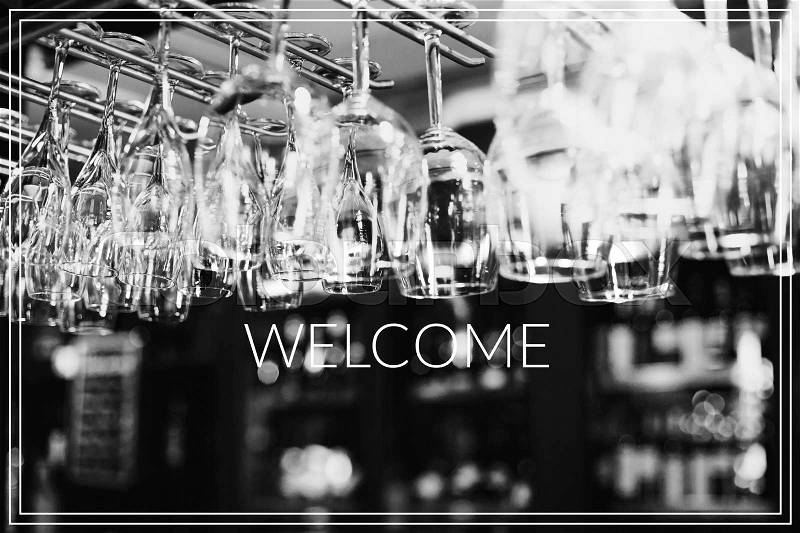 Welcome. Empty glasses for wine above a bar rack , stock photo