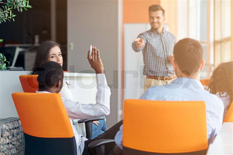Business, startup, presentation, strategy and people concept - man on presentation with group of people at office, stock photo