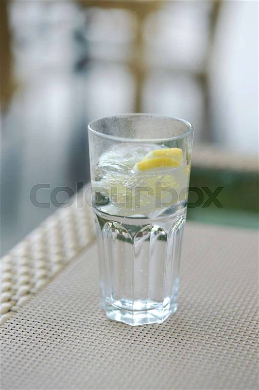 A glass of carbonated water and a lemon, selective focus, stock photo