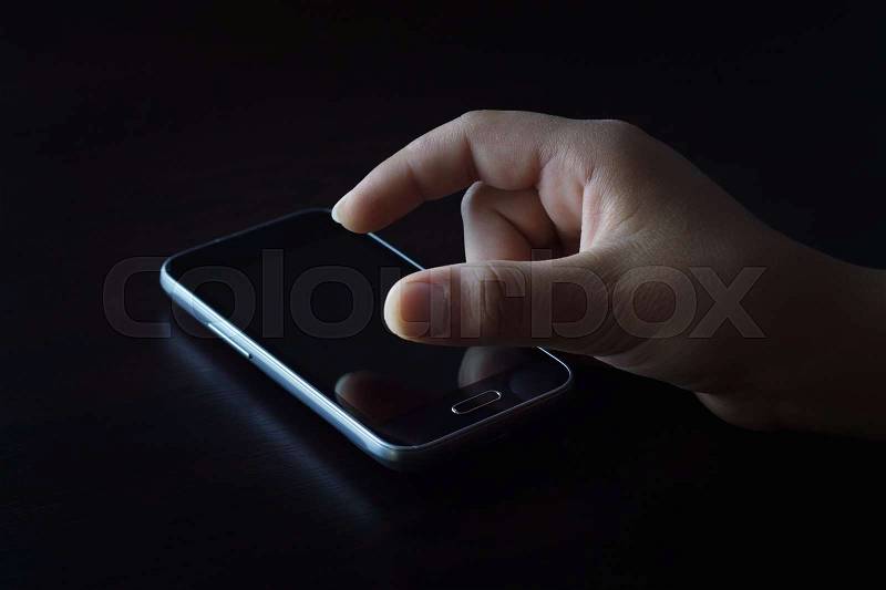 Fingers touch screen in the dark, stock photo
