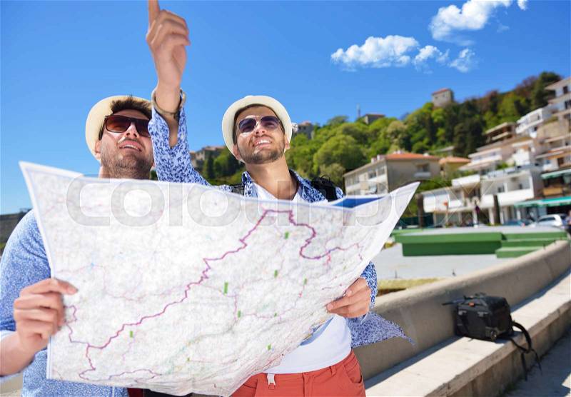 Portrait of a smiling tourist with map and bag, stock photo