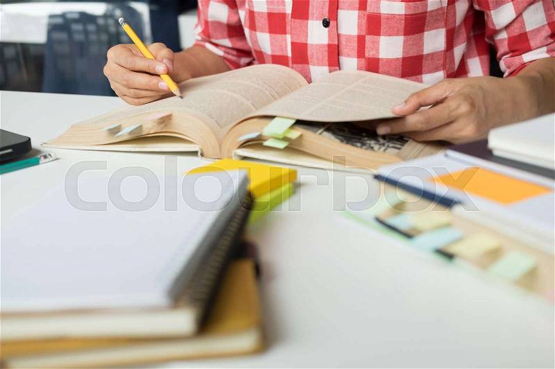 Young woman and man studying for a test/ an exam. Tutor books with friends. Young students campus helps friend catching up and learning. People, learning, education and school concept, stock photo