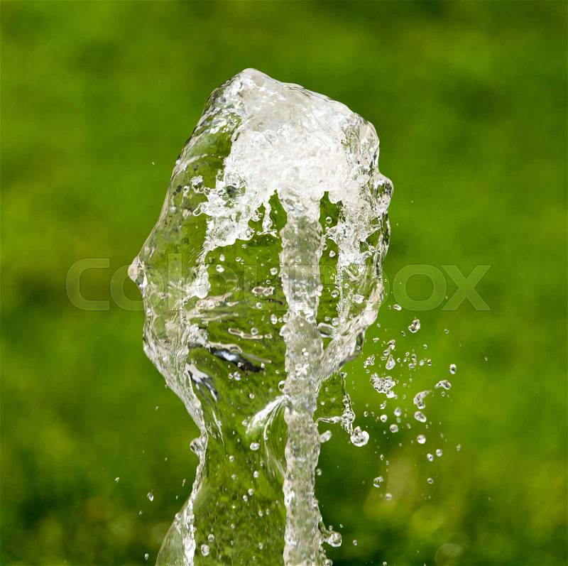 Splashing water from a fountain in the nature , stock photo