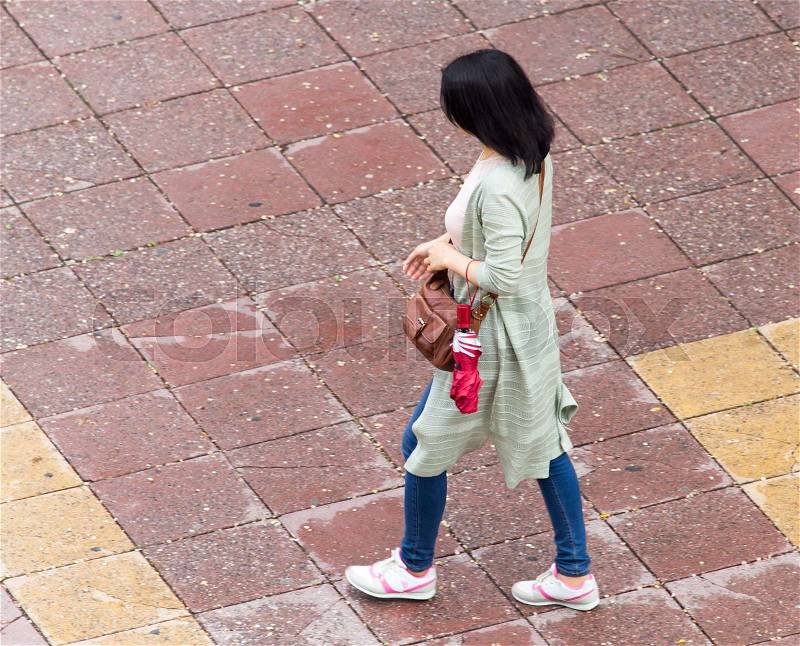The girl is walking along paving stones , stock photo