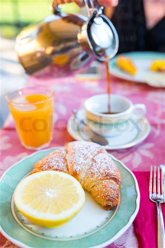 Tasty traditional appetizing yummy breakfast at the restaraunt outdoors. Fresh coffee and croissant, stock photo