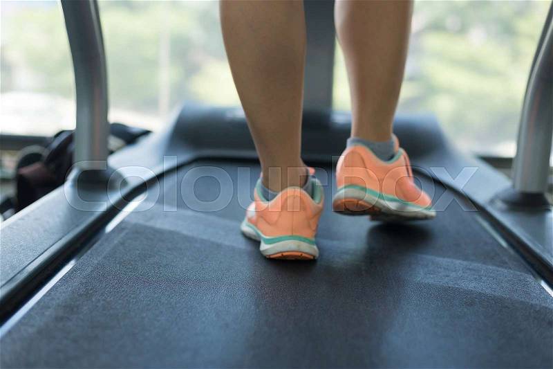 Close-up floor treadmill machine, human jogging exercise on run cardio equipment at sport healthy club center, stock photo