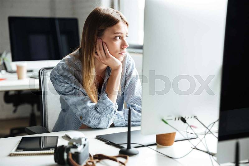 Image of serious young woman work in office using computer. Looking aside, stock photo