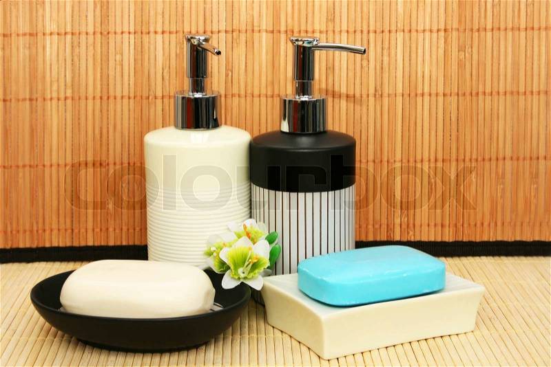 Soap dispensers and bars on bamboo, stock photo