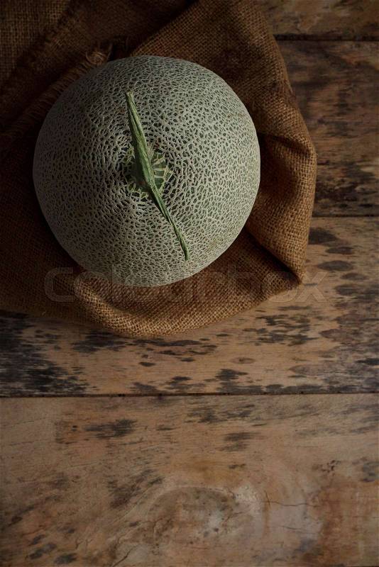 Melon green on sackcloth with wooden floor, stock photo