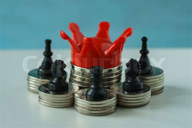 Miniature red crown king on stack of coins and chess symbol as financial business growth success concept, stock photo