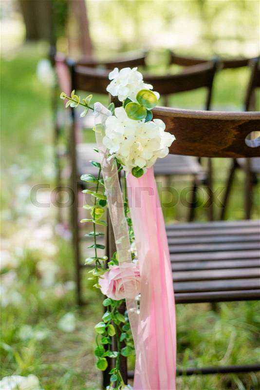 Beautifully decorated with flowers chairs for a wedding reception. Wedding decor, stock photo