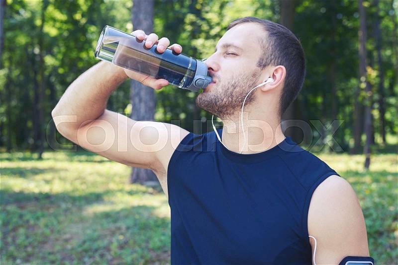 Close-up shot of a male drinking water; wearing sport cloth; closing eyes. Man having good posture and shape, stock photo