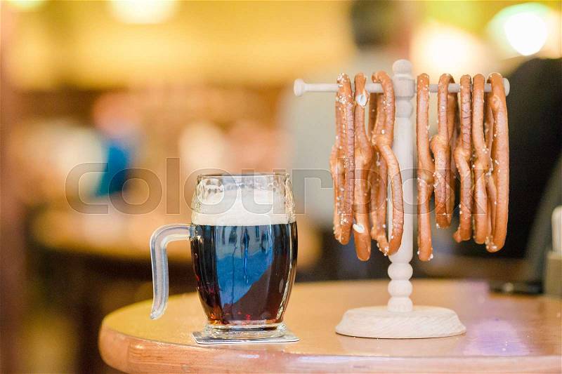 Close up salted tasty pretzels and beer on wooden background, stock photo