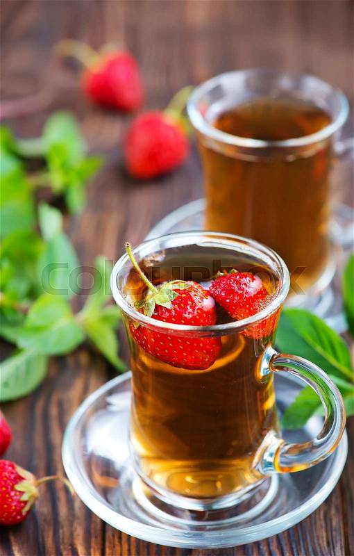 Strawberry tea in cups and on a table, stock photo