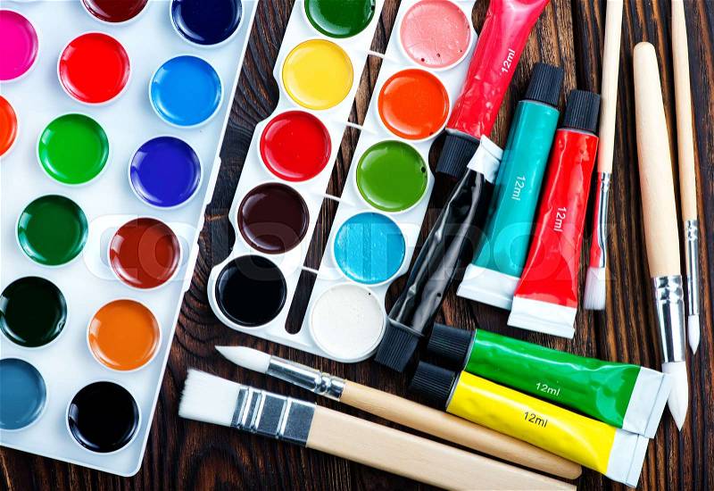 Color paint and brushes on a table, stock photo