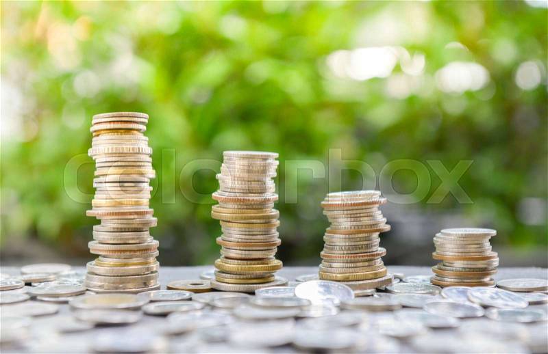 Growing coins stacks with sun light for saving money concept, stock photo